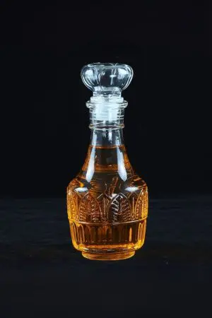 Carafe à whisky ronde en verre épais, décor gravé losanges et soleil, bouchon boule facettée, 850 ml, fond noir