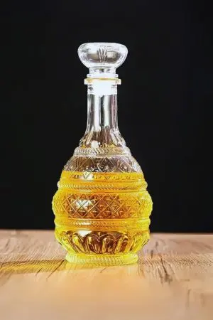 carafe à whisky en verre à motifs, posée sur une table en bois avec verre assorti