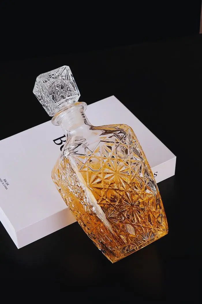 carafe à whisky en verre gravé Classic Star, bouchon carré, design étoilé, posée sur un livre blanc