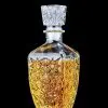 Carafe à whisky rétro en verre transparent gravé, remplie de whisky, posée sur fond noir.