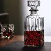 carafe à whisky moderne gravée, remplie de whisky ambré, posée sur une surface en verre