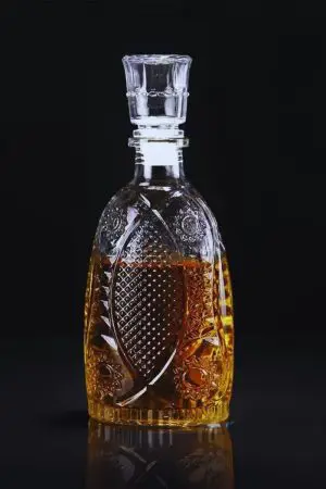 carafe à whisky vintage verre gravé bouchon cristal, remplie de whisky, fond noir
