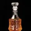 carafe à whisky vintage en verre gravé remplie de whisky sur fond noir