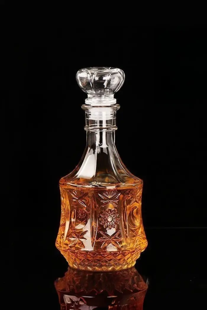 carafe à whisky vintage en verre gravé remplie de whisky sur fond noir