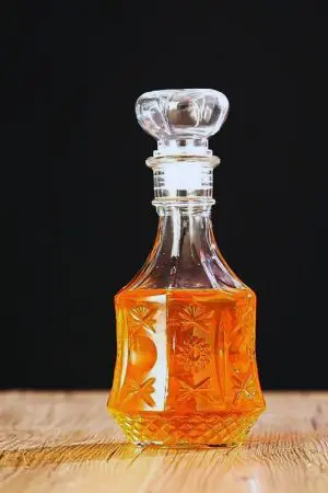 carafe à whisky hexagonale gravée sur fond noir avec whisky à l’intérieur
