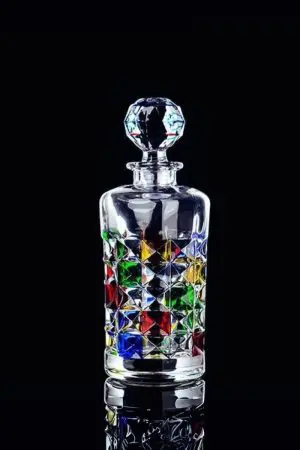 carafe à whisky en verre coloré sur surface réfléchissante, fond noir