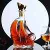 carafe à whisky bateau en verre sur fond noir avec disque blanc et verre ballon
