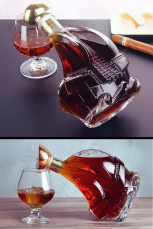 carafe à whisky bateau en verre couchée à côté d’un verre ballon, deux scènes