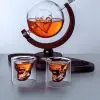 carafe à whisky globe crâne sur socle en bois et deux verres, fond clair