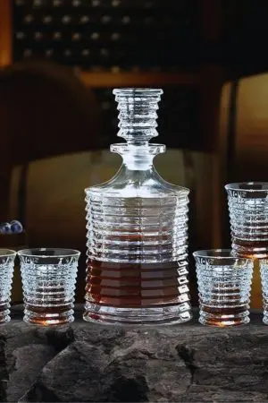carafe à whisky en verre cannelé avec verres assortis posés autour