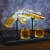 carafe à whisky revolver sur socle noir avec deux verres.