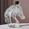 carafe à whisky tête de cheval en verre vide posée sur table blanche avec bouchon noir