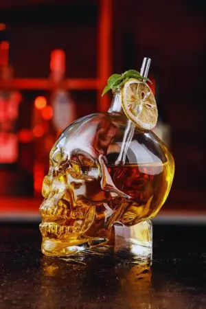 carafe à whisky tête de mort en verre avec paille, tranche de citron et menthe
