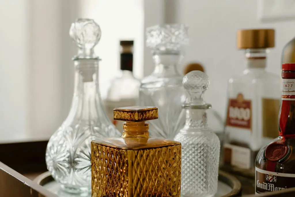 ensemble de carafes à whisky en verre transparent et ambré de tailles variées posées sur un plateau de service