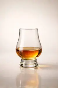 Variante de verre Glencairn contenant du whisky, posée sur surface claire