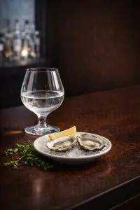 verre de rhum blanc servi avec huîtres sur glace et quartier de citron