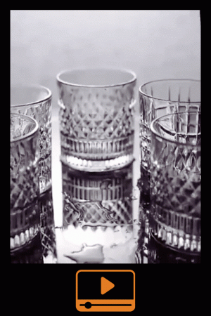 Verres à whisky cristal tumbler posés en groupe sur une surface réfléchissante, animation en noir et blanc.